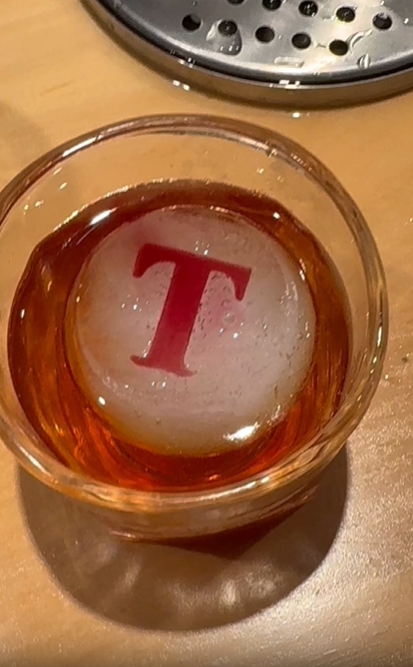 A custom ice sphere is pressed with a monogrammed "T" in the Ice Insignias custom sphere press.